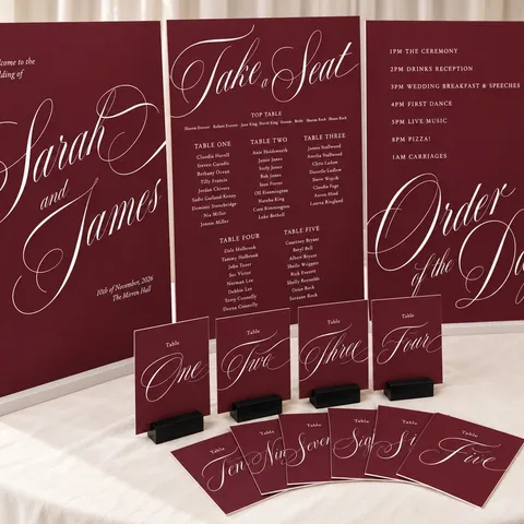 Burgundy Solenne wedding signs by Mally’s Crafts featuring white Juliette calligraphy across a welcome sign, seating plan, order of the day and table numbers.