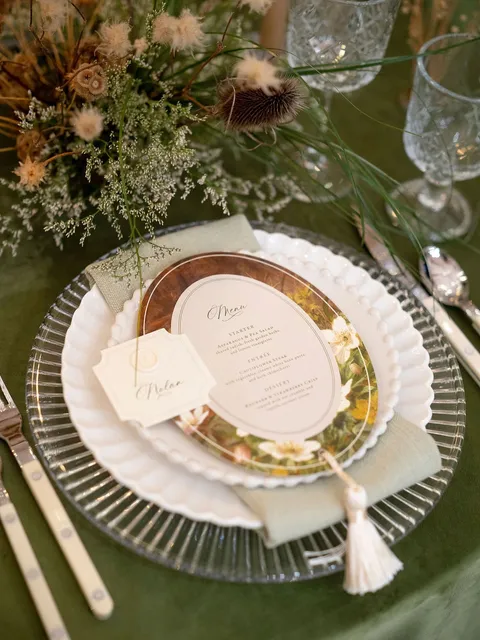 Oval wedding menu and tasseled place card by Paper Palette featuring La Rumba calligraphy, styled by Tufts & Toile. Photograph by Brittany M. Williams.