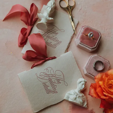 Decorative wedding details cards by Ashley Barado of InvitoBella with red Juliette calligraphy, scalloped edges and coral ribbon.