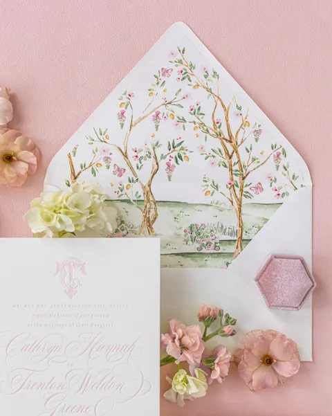 Chinoiserie envelope liner with flowering branches and birds beside pink Juliette wedding stationery by Empress Stationery.