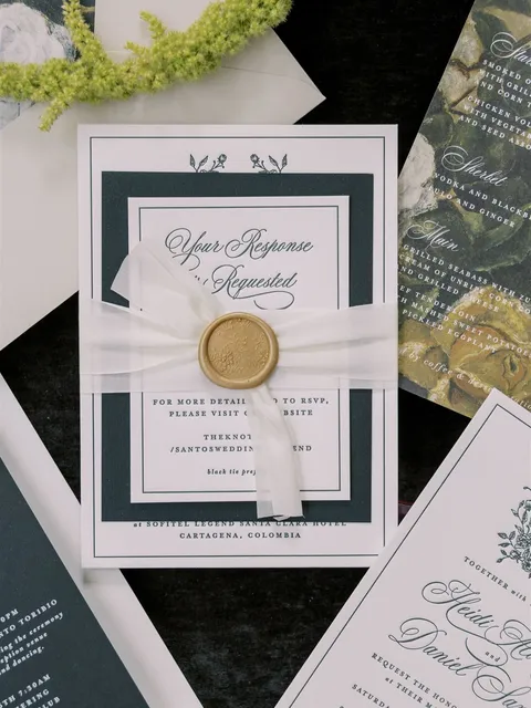 Layered pink and green wedding invitation by Cojo Moxon Design featuring Juliette calligraphy, a vellum wrap and gold wax seal. Photograph by K&K Photography.