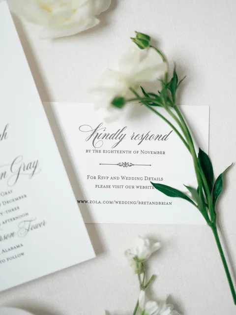 RSVP card by Patricia Campbell of Fine Paperwork featuring Mozart Script calligraphy by Blessed Print, styled with white flowers.