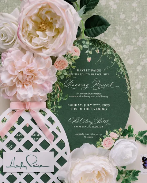 Green botanical invitation by Rue Paperie for the Hayley Paige collection preview, featuring La Rumba calligraphy, pink flowers and lattice details. Photograph by Annie Lui Photography Flatlays.