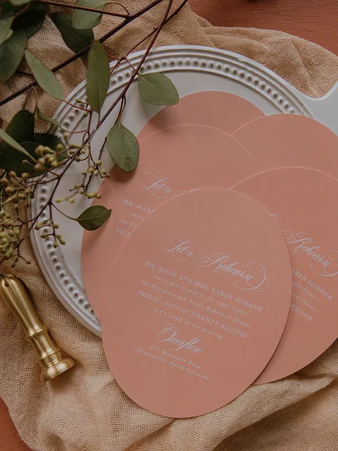 Terracotta rehearsal dinner cards with rounded edges and white Mozart Script calligraphy by Anna Howe.
