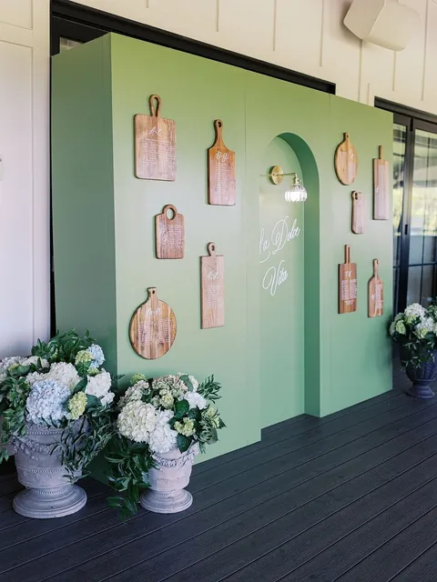 Green wedding seating display by Script Your Event with Juliette calligraphy, hanging decorative boards and white hydrangeas. Photograph by Mike Cassimatis.