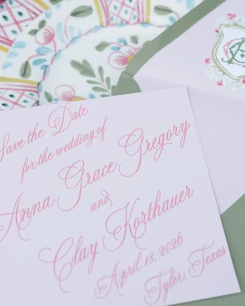 Pink save-the-date card by Claire Hodges Weddings featuring Juliette calligraphy, a green envelope and a colorful botanical liner.
