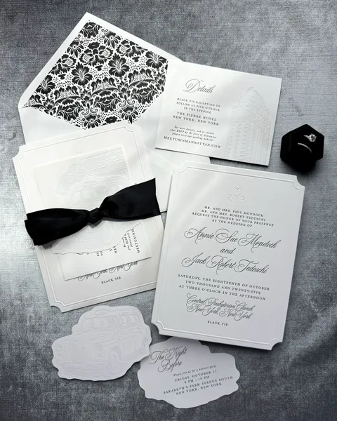 Black and white wedding invitation suite by Glow Paper Co. with Juliette calligraphy, shaped insert cards, a patterned liner and black ribbon.