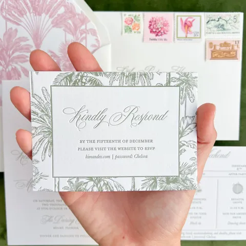 Letterpress RSVP card by Little Postage House featuring Mozart Script and a green palm tree border, held above coordinating tropical wedding stationery.