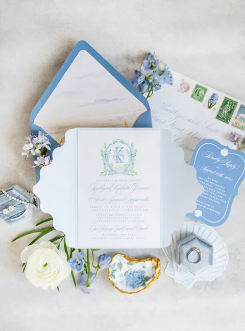 Blue coastal wedding invitation suite by Cojo Moxon Design featuring Juliette calligraphy, a watercolor shell card and a wavy gatefold. Photograph by Kaitlyn Ferris.