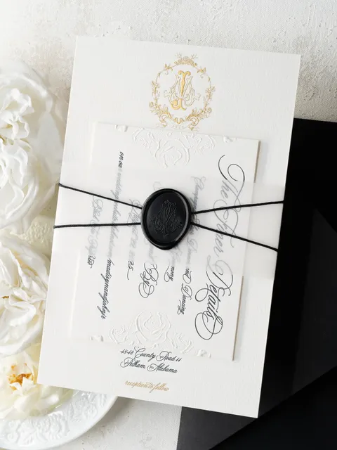 Wedding invitation by Ledgewood Fine Stationery featuring Juliette calligraphy, a gold crest, black string and a black wax seal. Photograph by Peterson Design & Photo.