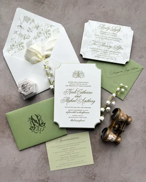 Green botanical wedding invitation suite by Glow Paper Co. with Juliette calligraphy, a floral envelope liner, monogram and cream ribbon.