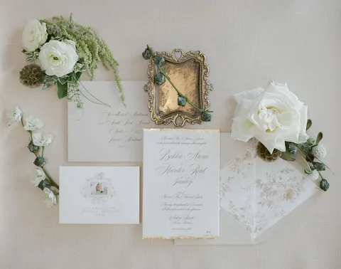 Wedding stationery by Janeil Anderson of Seventh & Anderson with Juliette calligraphy and gold detailing, styled with white flowers. Photograph by Anna Suprunchik.