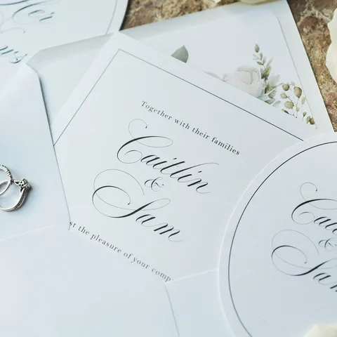 White Lovelle wedding invitation and oval coordinating cards by Mally’s Crafts featuring black Juliette calligraphy. Photograph by Kris Karl Weddings.