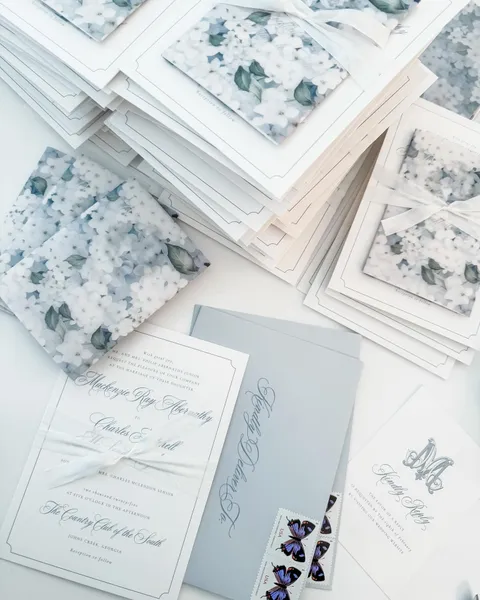 Wedding invitation assembly by Sincerely Rachel with Juliette calligraphy, pale blue cards, floral envelope liners and vintage postage.
