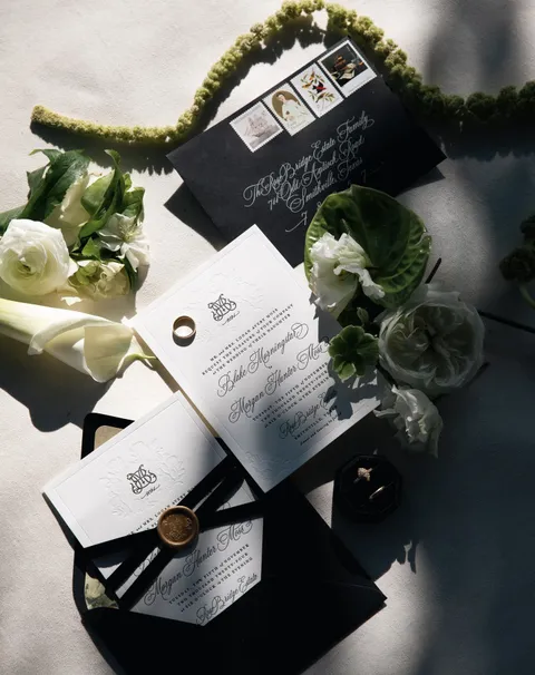 Black and white wedding invitation suite by Cojo Moxon Design featuring Juliette calligraphy, a crest and illustrated liners. Photograph by Candid Bliss Photos.